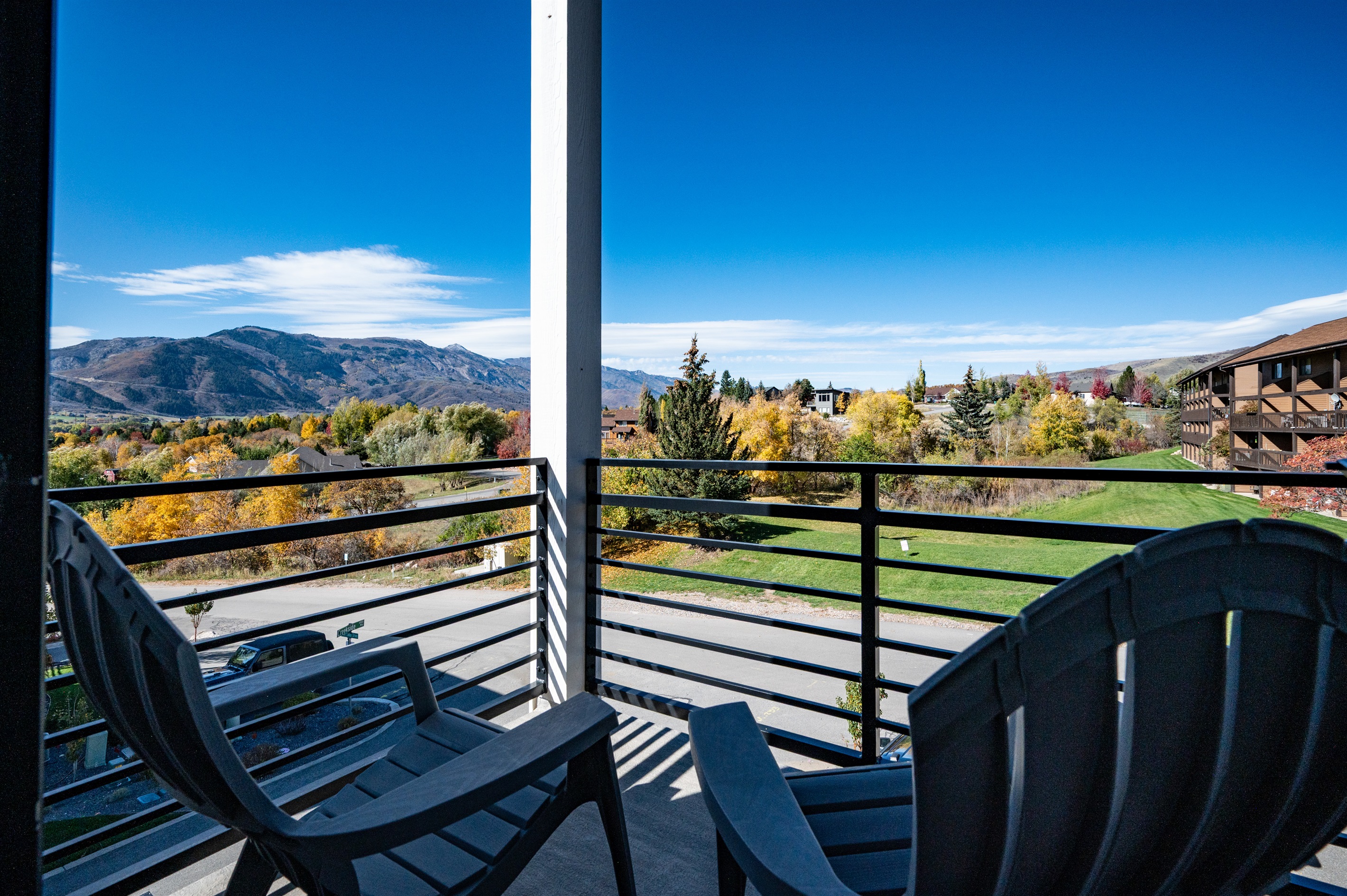 Private balcony off Bedroom 1 with seating for two and scenic views.