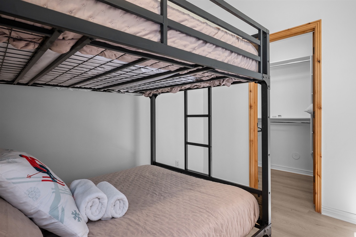 ower-level bedroom featuring a double-over-double bunk bed and walk-in closet — perfect for kids or extra guests.