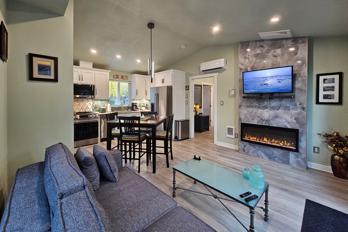 Gather in the heart of the cottage, where an electric fireplace provides ambiance with entertainment from a SmartTV with cable and sound system.  Sofa extends into a queen bed, allowing the cottage to sleep 4.