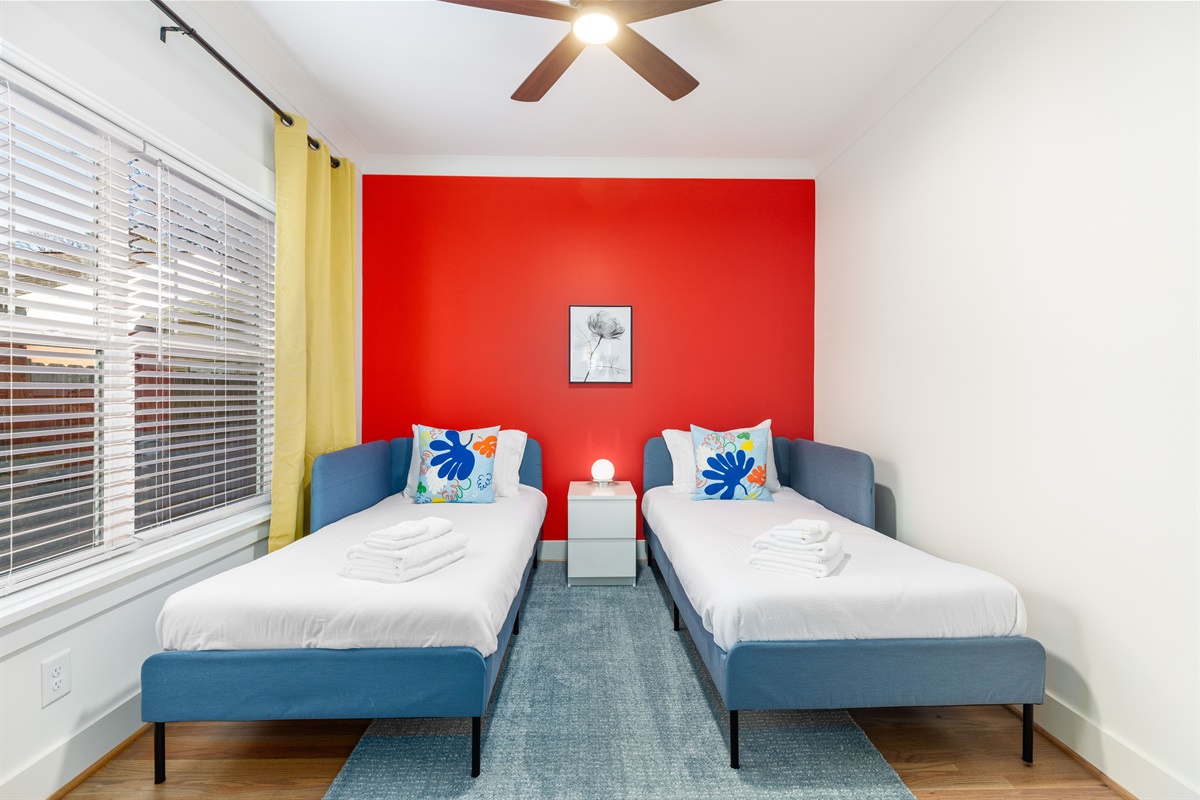 The upstairs twin bedroom has access to a full bathroom shared with the queen bedroom next door. Pull the blackout curtains to sleep in!
