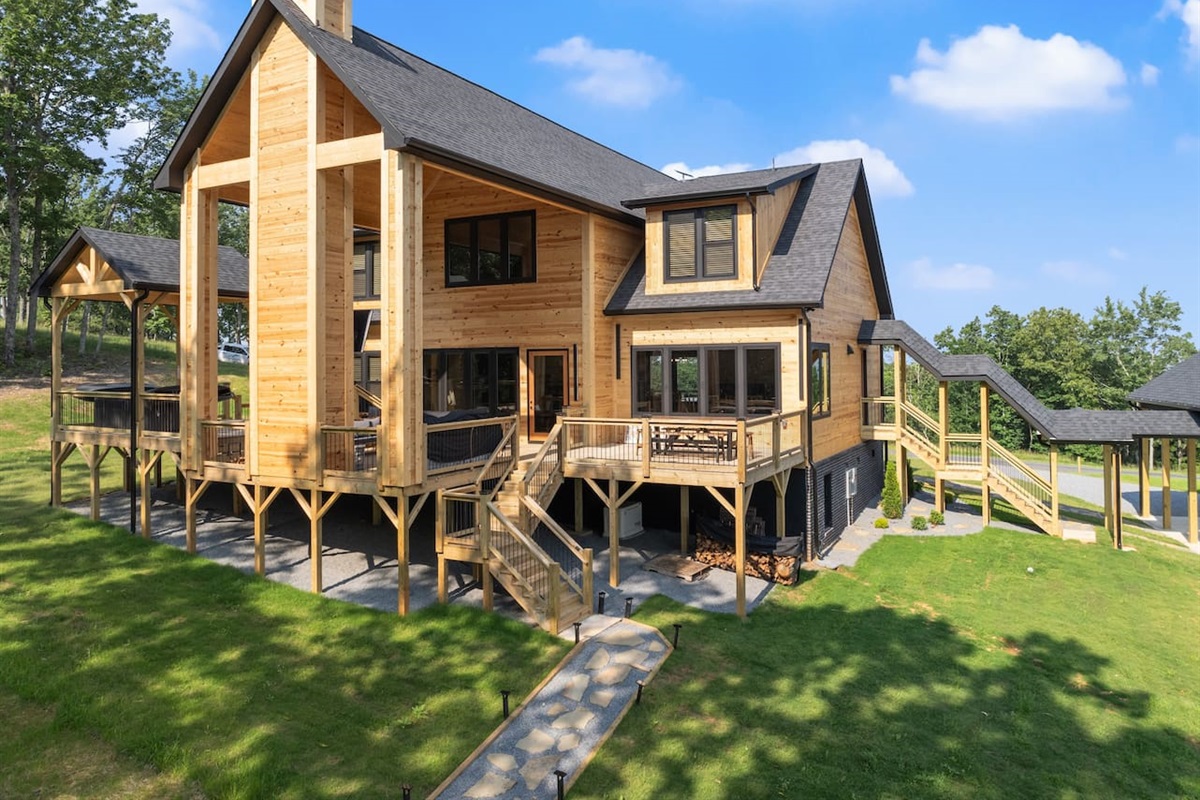This rear view highlights the cabin’s stunning architecture, multiple decks, and cozy outdoor nooks.