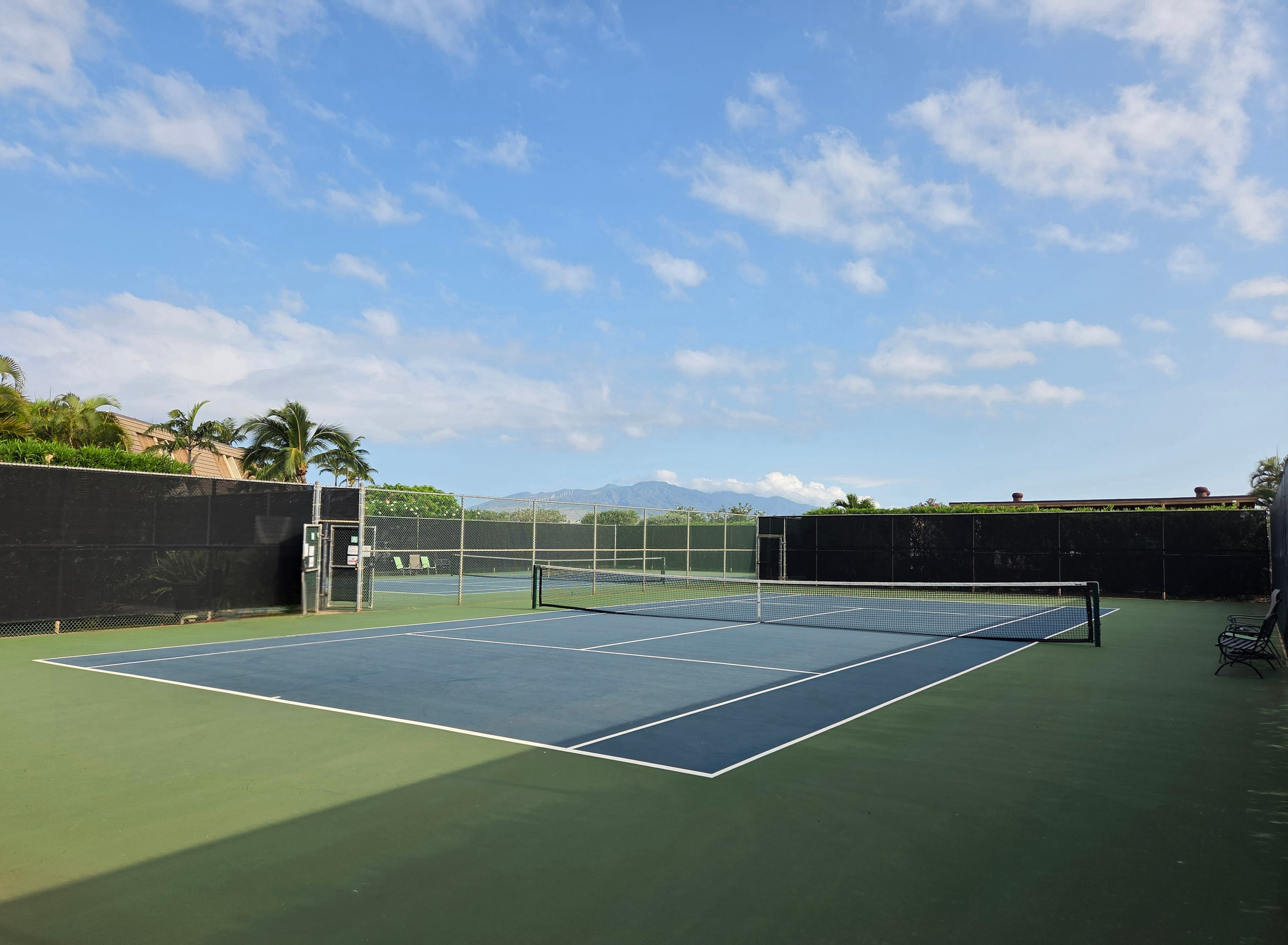 Two tennis courts, sign-up sheet just outside the courts