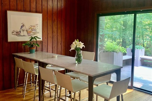 Cabin vibes meet mid-century modern meet formal yet playful luxury in this dining room. There's  seating for 9 at these CB2 marble high top dining tables with CB2 white leather chairs. Located between the kitchen and one of two entrances to the deck.