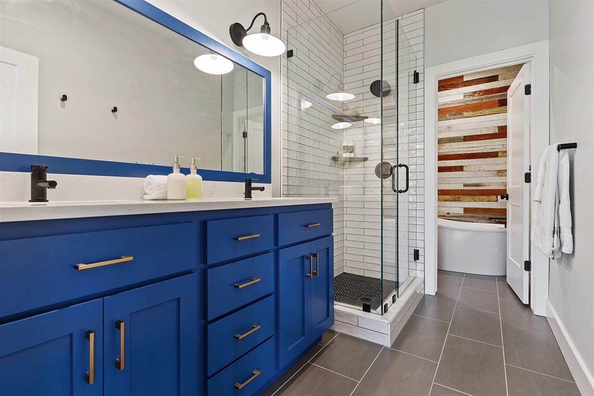 Unwind in a spa-inspired bathroom complete with a dual vanity, upscale finishes, and a sleek glass-enclosed shower.