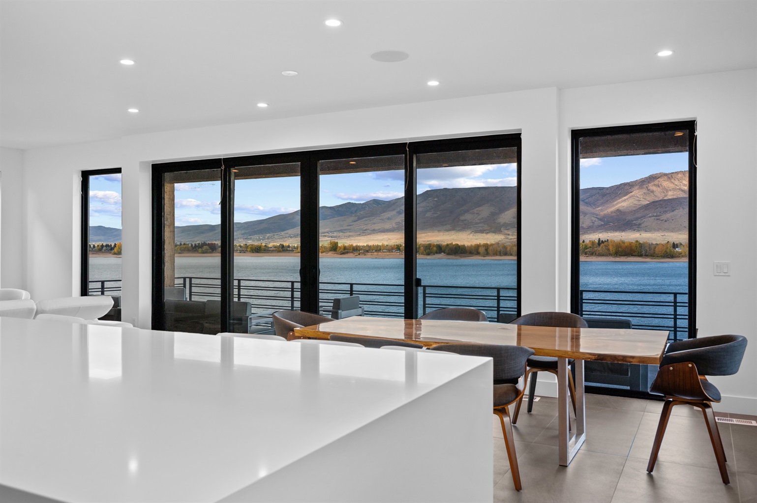 Contemporary kitchen featuring high-end appliances, large island with seating for six, and open layout to the dining area.