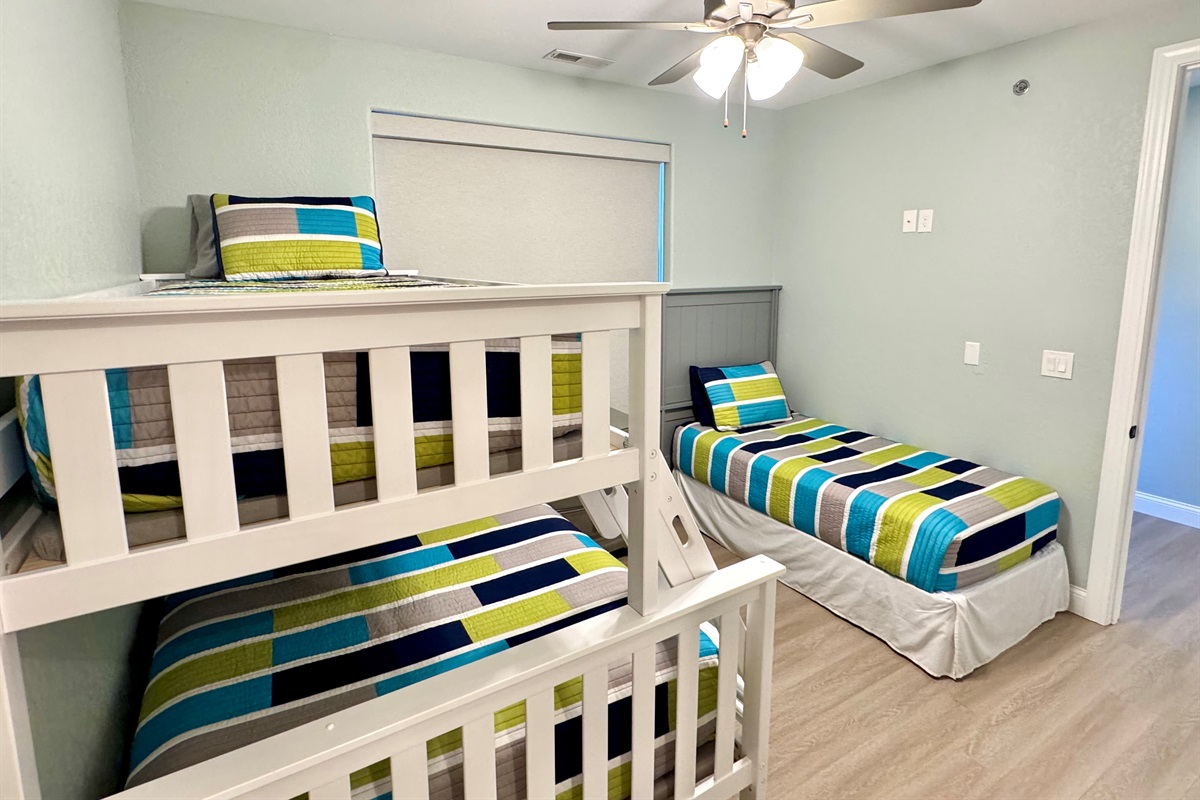 Guest Bedroom 3 has a twin bunk bed over a full bed and another twin bed, closet, and private en suite bathroom.