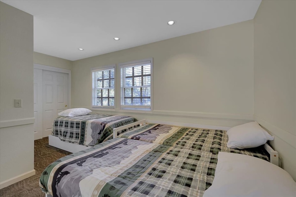 Bedroom 3 with three twin beds and a simple setup for kids, friends, or extra guests.
