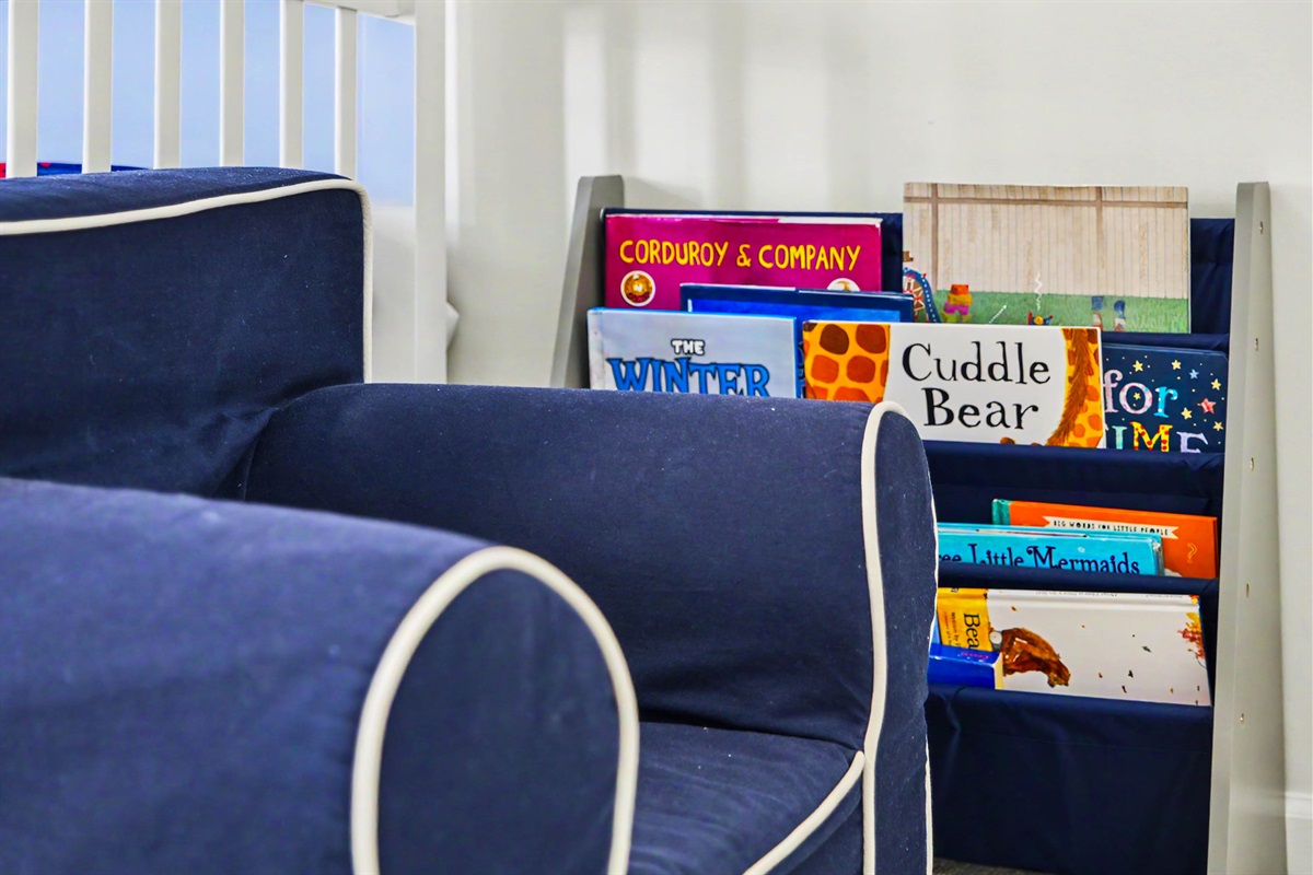 Lots of kids books, toys + cozy reading chair