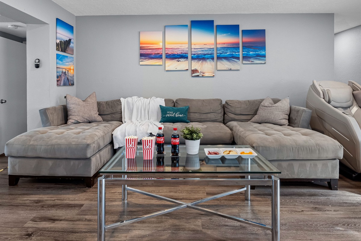 This spacious living room features a plush sectional, sleek decor, and contemporary artwork that blends perfectly with the modern aesthetic.