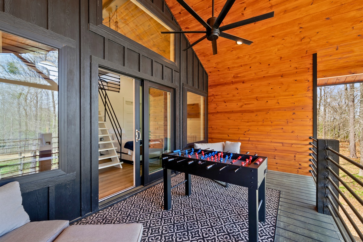 Step out onto the covered deck where seating and games create a laid-back outdoor living space that’s perfect for relaxing or hanging out.