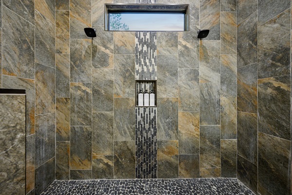 Designer ensuite with a stone walk-in shower and rustic timber accents.