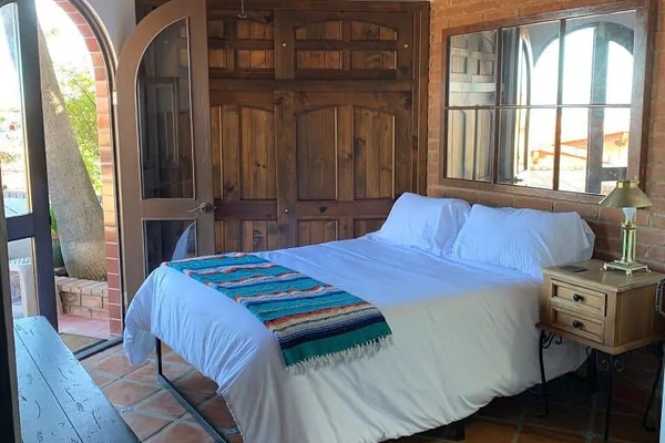 Queen-size bed
Luxury linens
Ceiling fan
French doors opening to patio
Adjacent bathroom with shower.