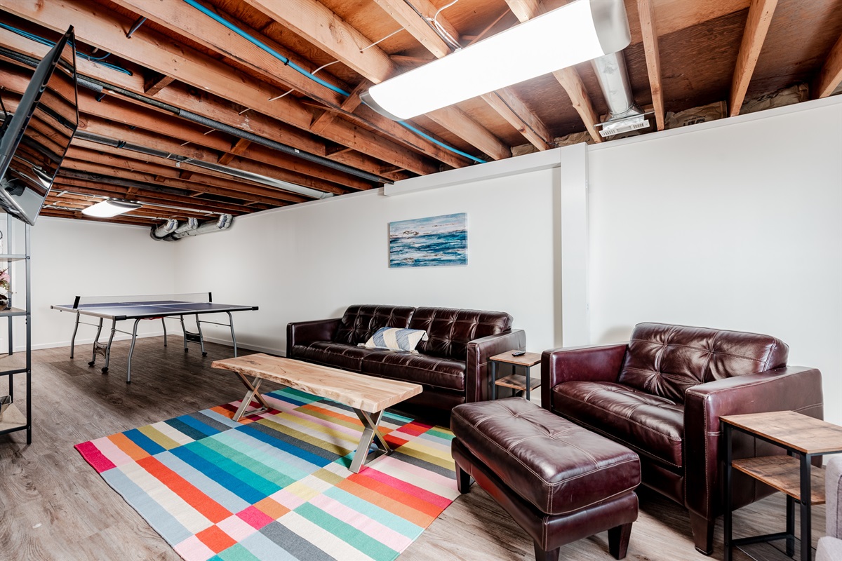 Basement level with ping pong table, seating, and a Roku tv