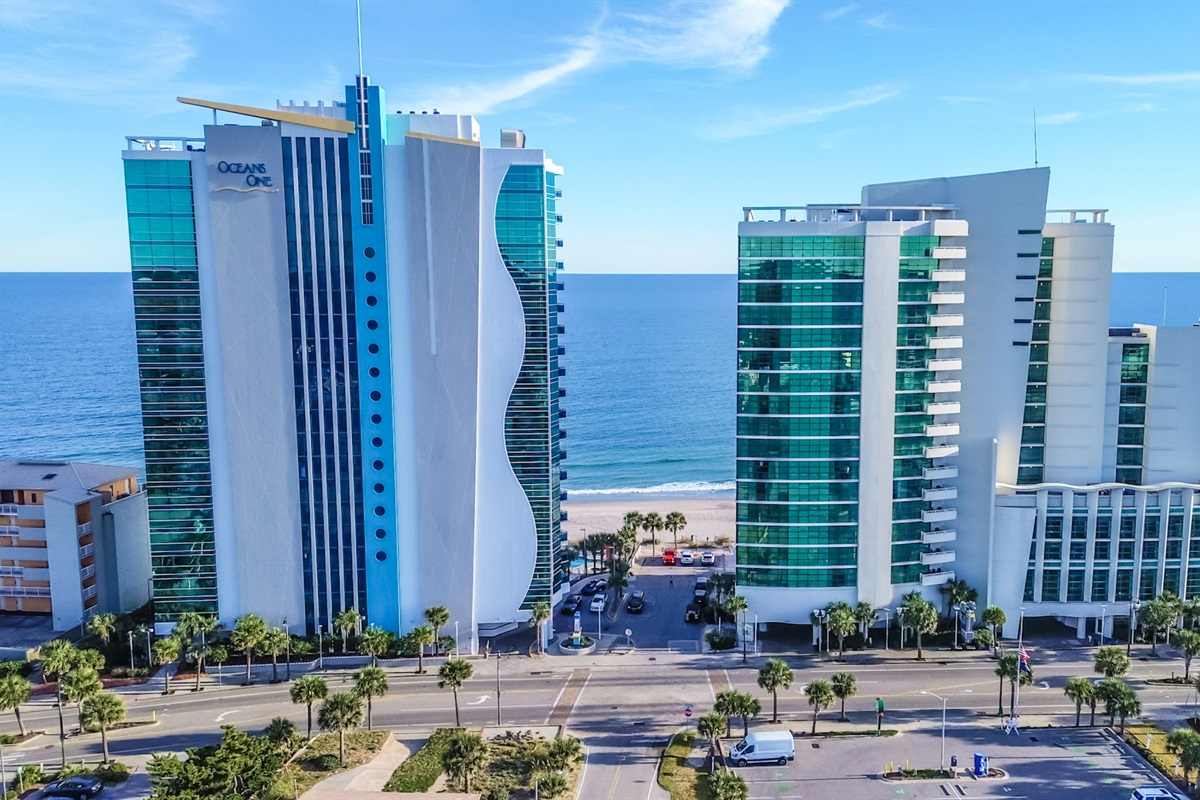 - Oceanfront resort building exterior featuring tall windows and unique blue trim   - Modern architecture highlights Myrtle Beach skyline with contemporary coastal look   - Vacation stay offer