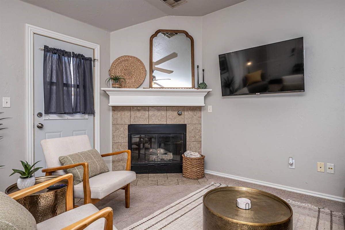 Spacious living area featuring comfortable seating, smart TV, and a warm fireplace.