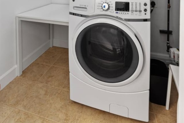 Convenient full-sized front-loading washer tucked away in the utility closet.