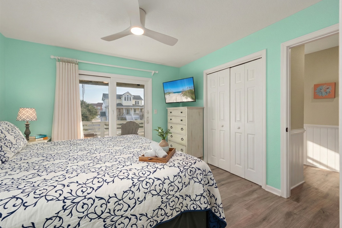 ML Bedroom 5 -  Cozy bedroom with a vibrant coastal color palette and private balcony access.