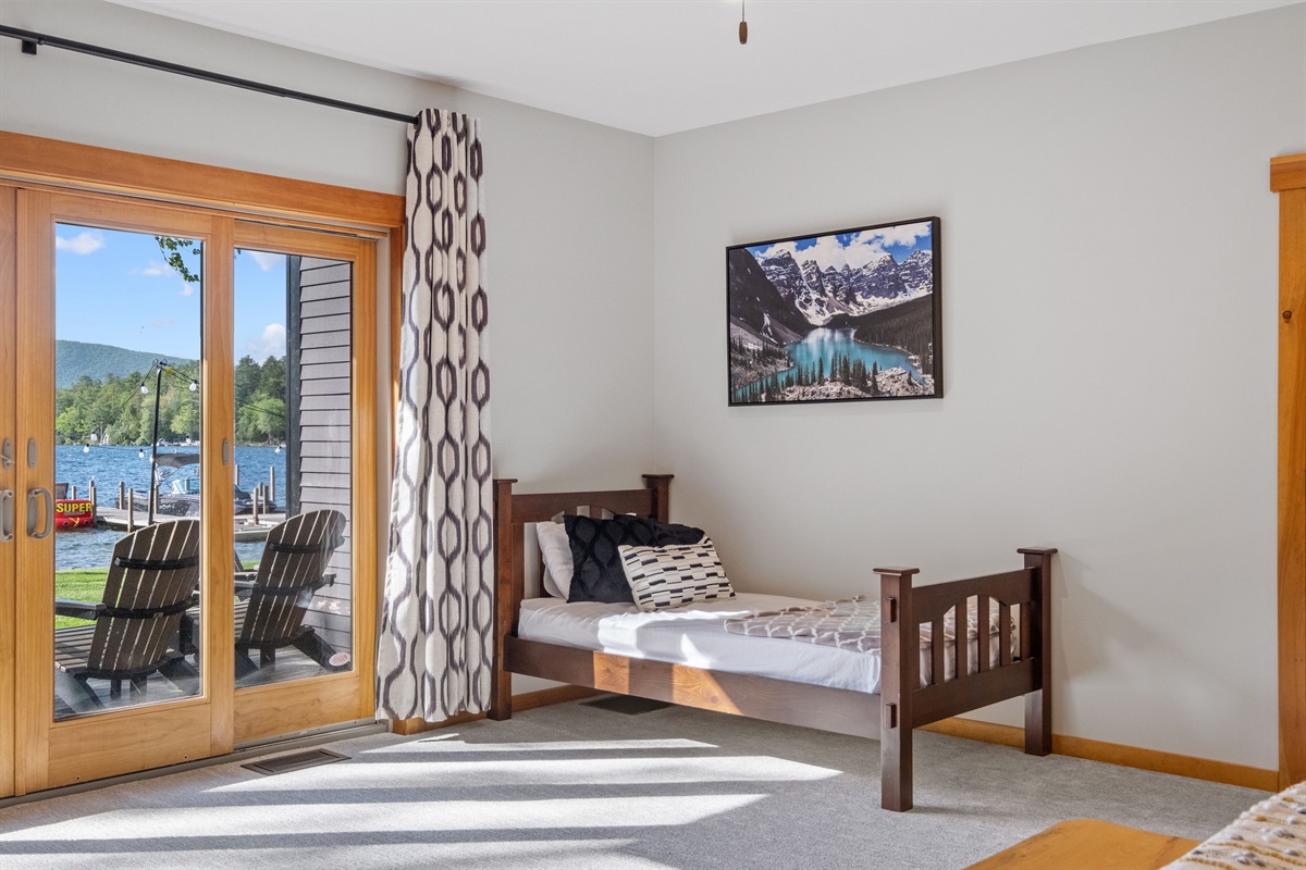 First floor master bedroom ensuite with king and twin beds overlooking Lake Winnipesaukee with hot tub on outside deck.