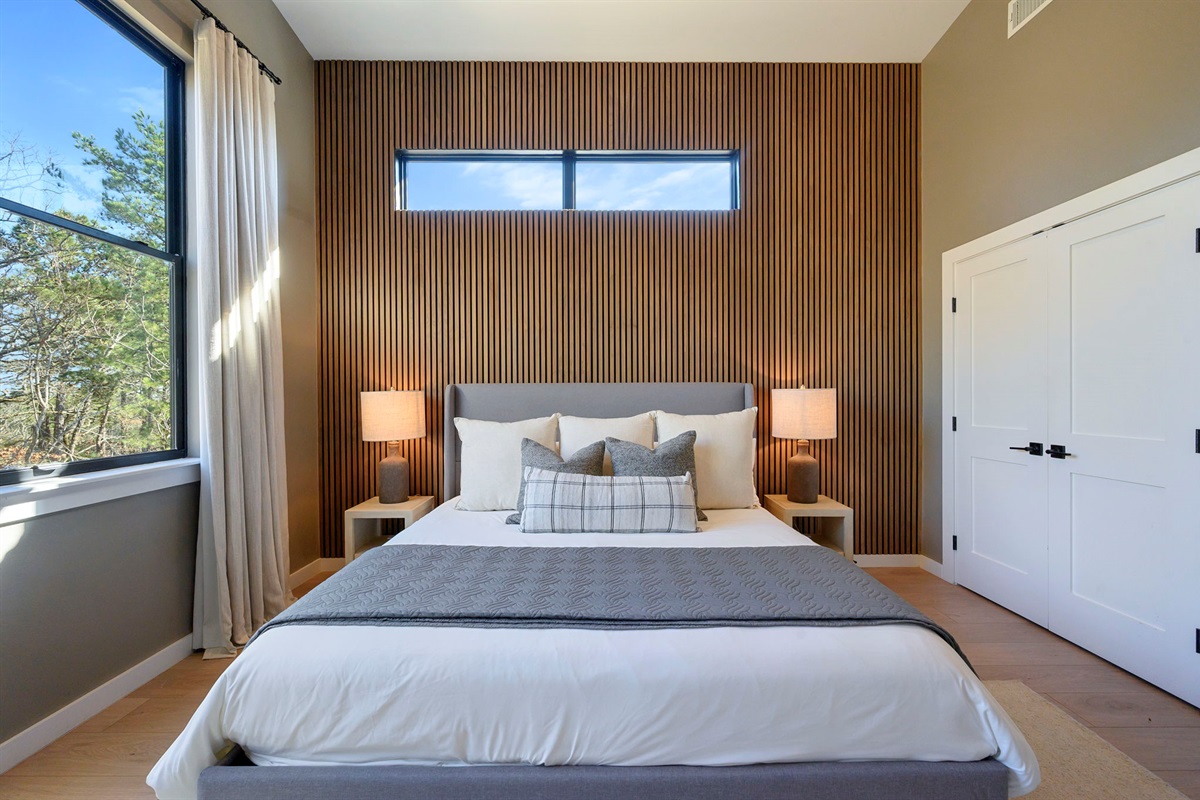 King Suite 2 - Large and spacious suite with teak wood paneling, designer finishes, smart TV, premium king mattress, and luxury bedding. Includes stunning views of the hardwood forest. 