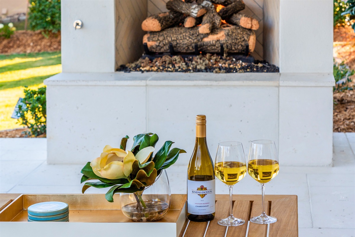 Outdoor fireplace setup with wine for cozy evenings.