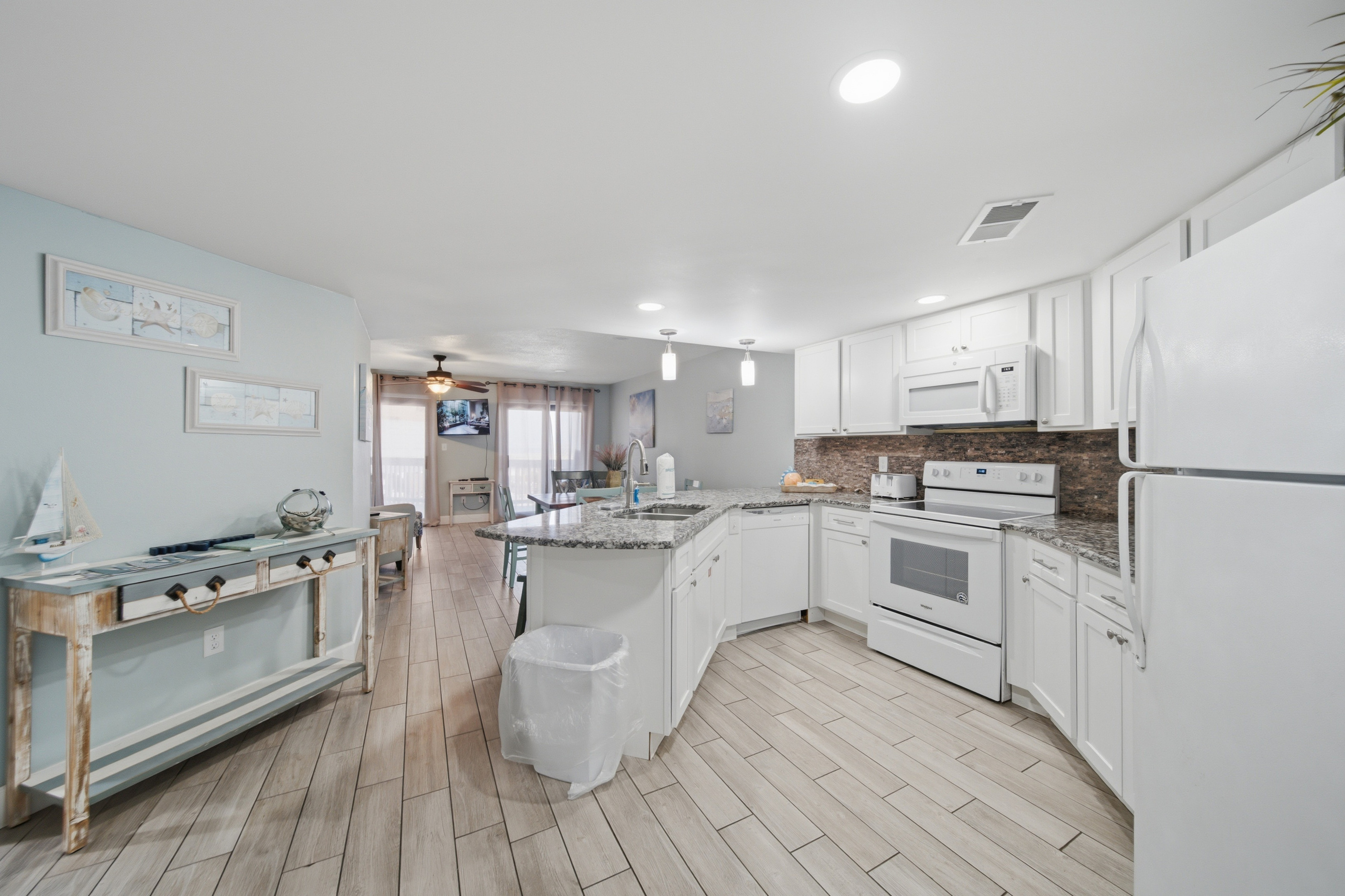 Fully equipped kitchen with white cabinetry and full-size appliances