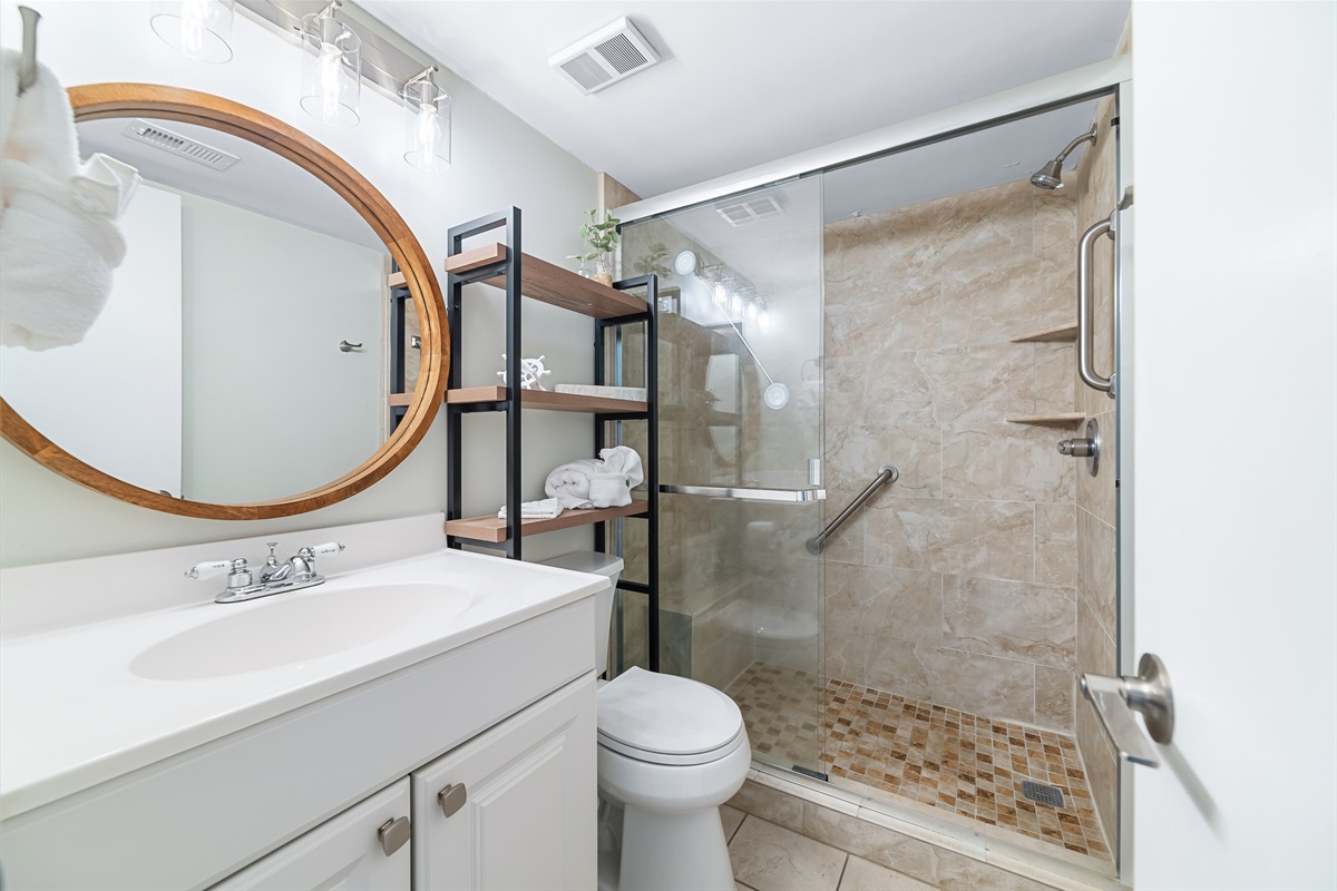 Modern and clean design. With ample lighting, a walk-in shower, and fresh coastal decor, this bathroom provides all the necessary comforts for a seamless stay.