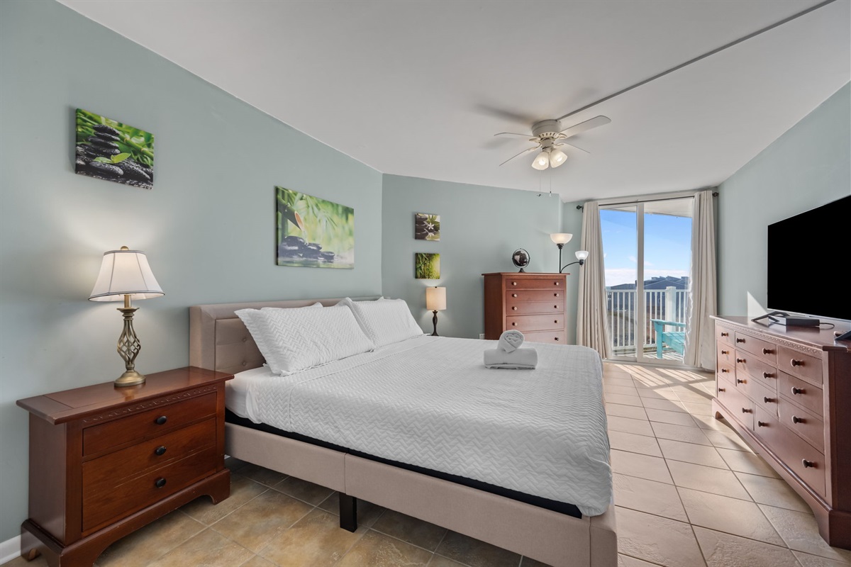 Bright and airy Master bedroom featuring a King bed, ample storage, and natural light from the balcony doors