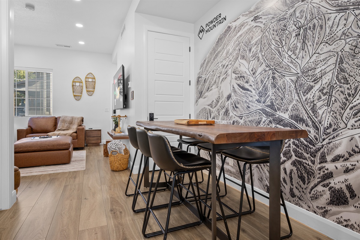 Dining area with seating for six beneath map of powder mountian..