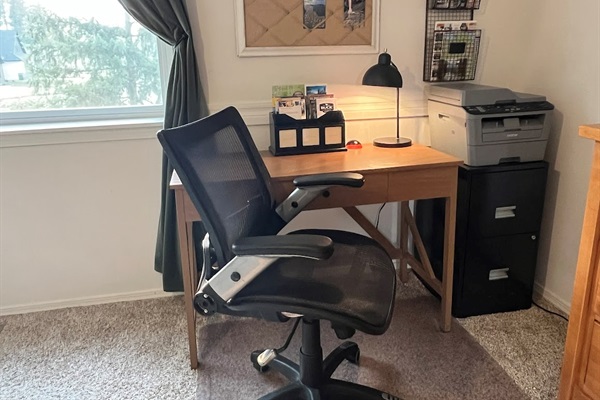 Workspace located in the primary bedroom with a desk, office chair, and printer. High-speed Wi-Fi throughout the home.