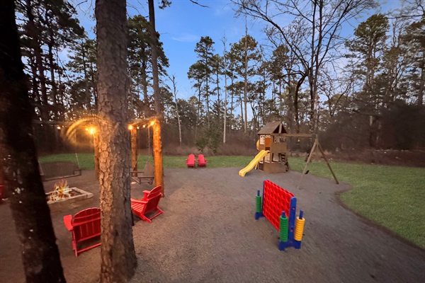 Bistro lights around the firepit and side yard with playset and Connect 4.