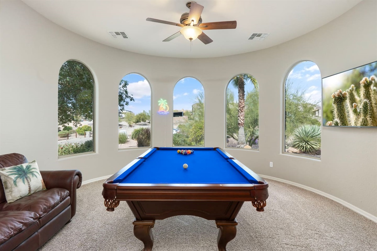 Bright and inviting entertainment space — shoot some pool, watch TV, or unwind on the leather sofa after a long day.