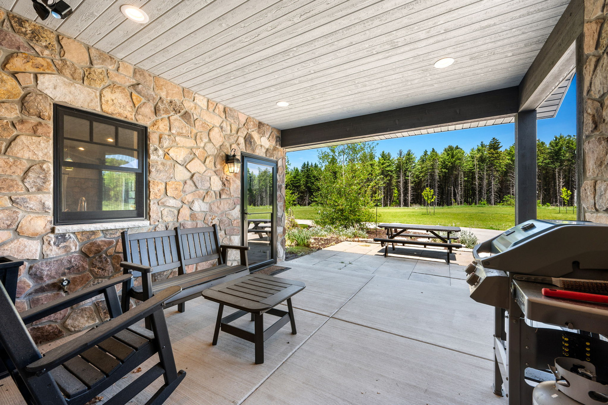 Step outside to the covered patio and take in the picnic table, grill, and unobstructed views of the lush lawn and pine forest.