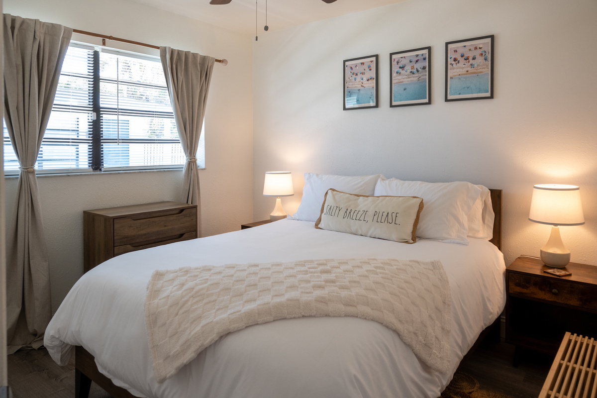 Bedroom 1 with dresser, nightstands and soft lamplight