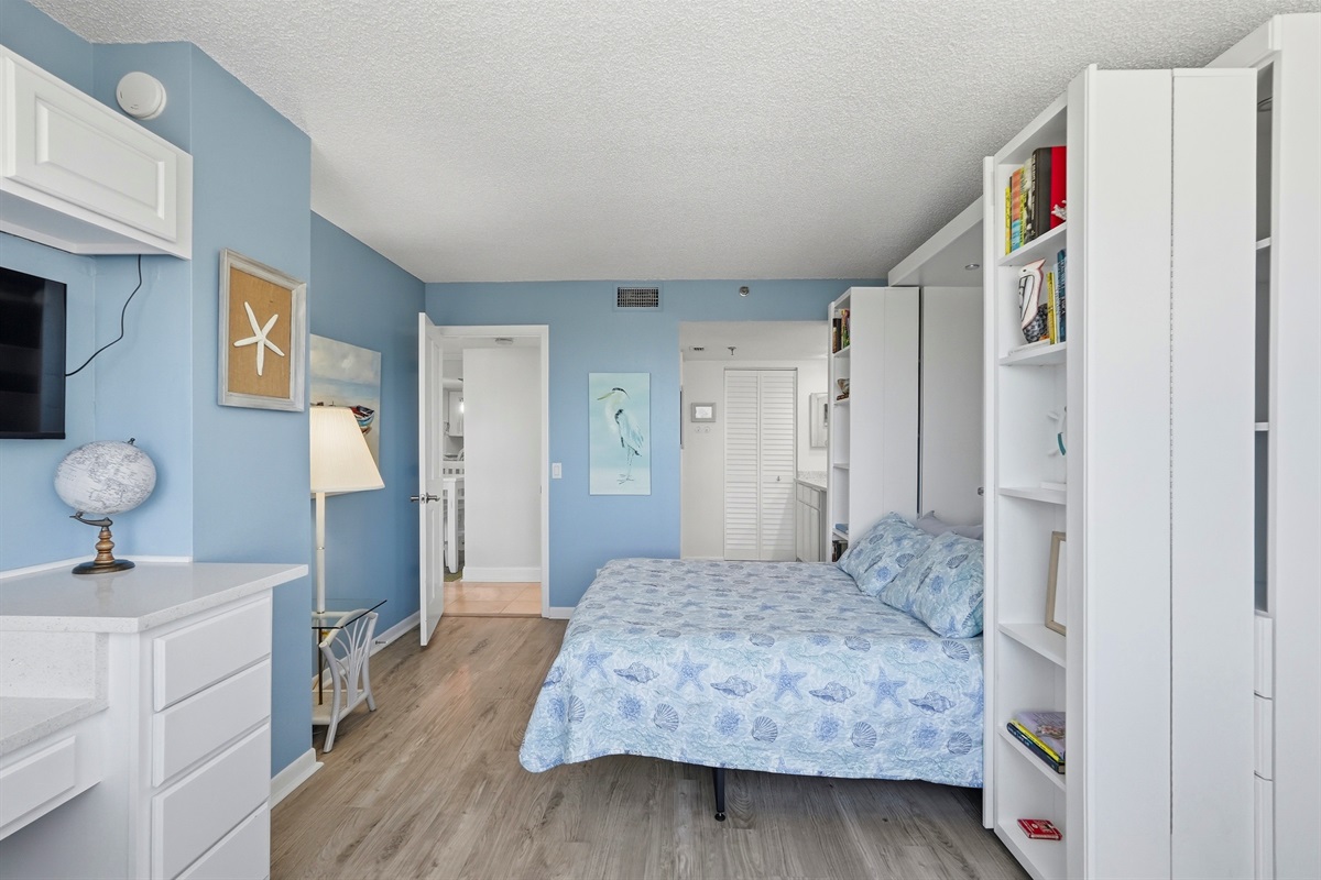 The second bedroom offers a relaxing space featuring a comfortable Murphy bed, stunning bay views, and plenty of closet storage. It also includes a dedicated workstation, making it ideal for working professionals or guests needing a quiet space.