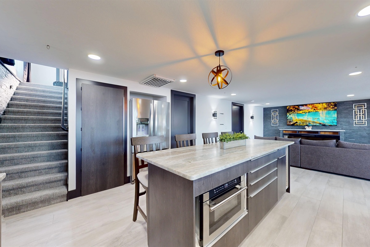 Large Kitchen with a microwave in the center island, gas stove and range, pantry, bar seating for 4, and refrigerator.