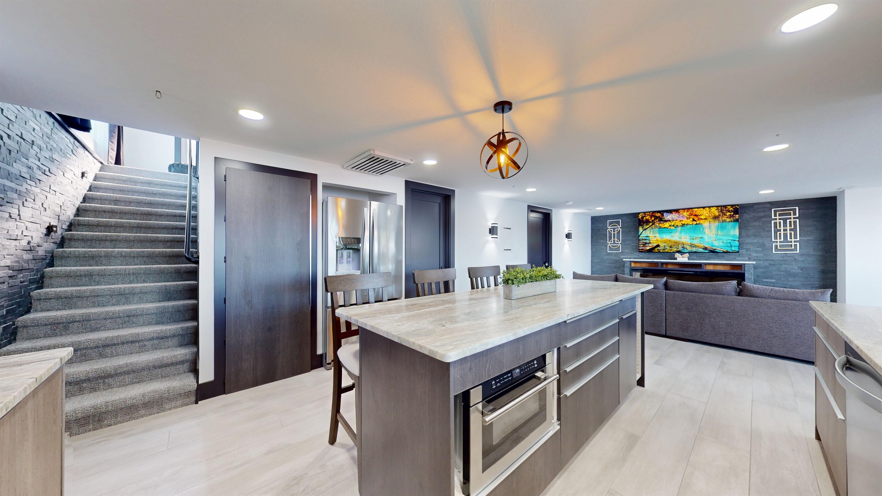 Large Kitchen with a microwave in the center island, gas stove and range, pantry, bar seating for 4, and refrigerator.
