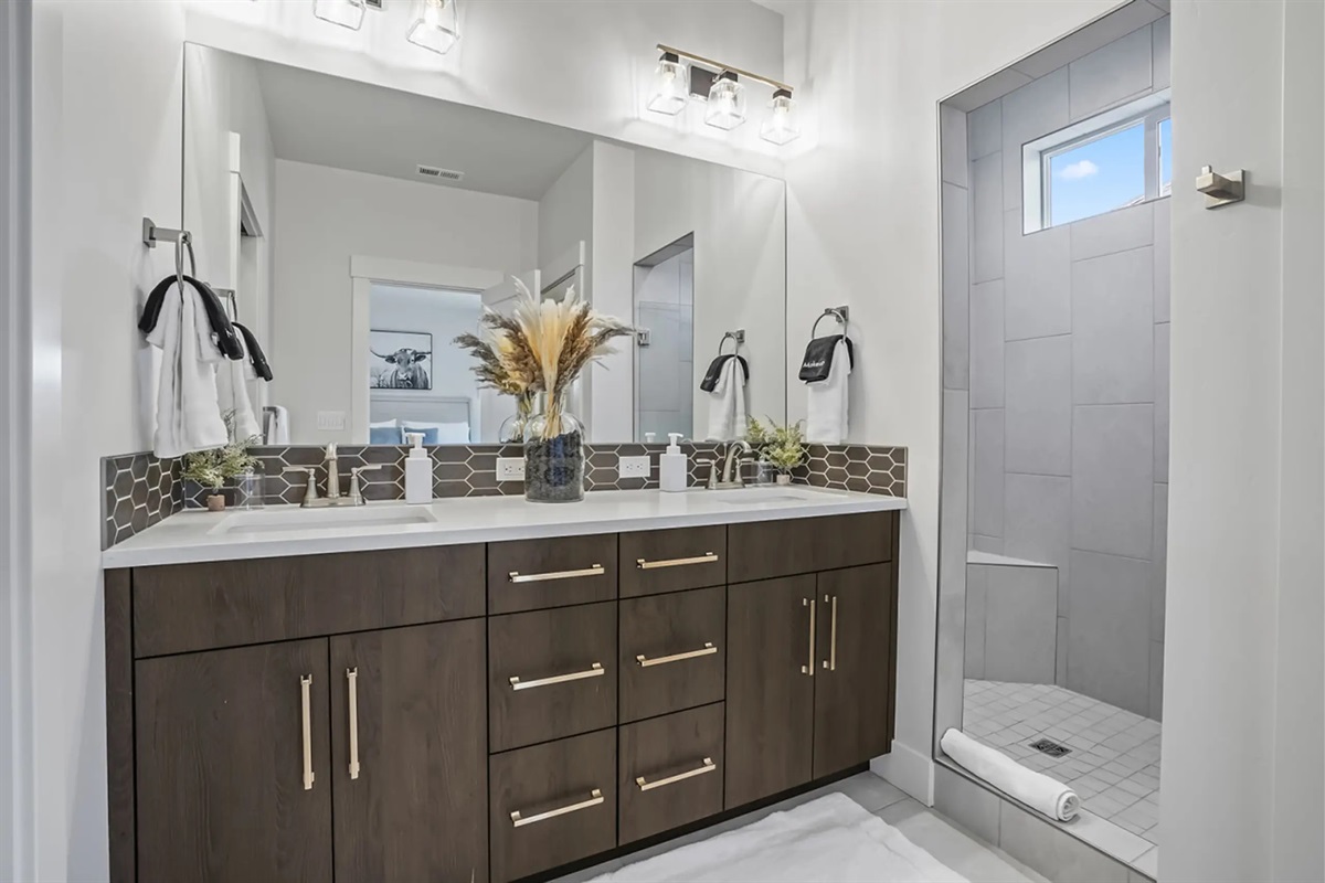 Stylish bathroom with double sinks and a spacious walk-in shower.