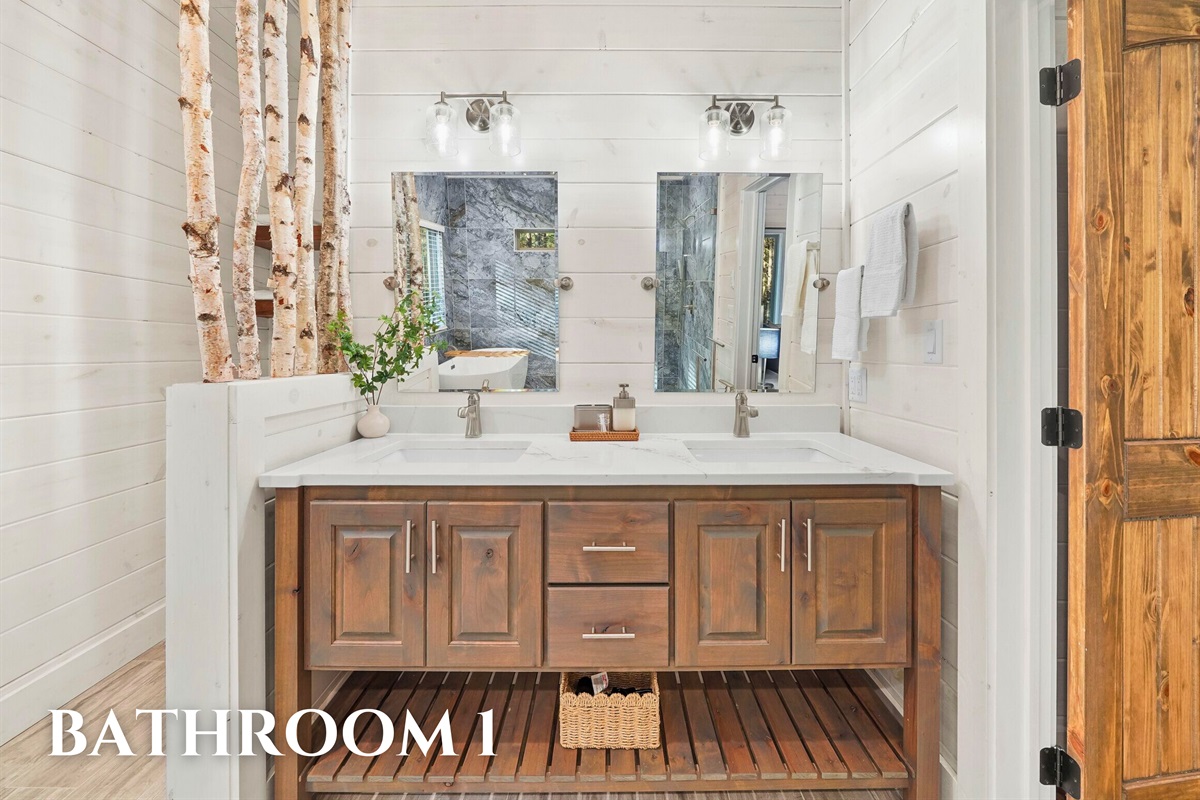 Bathroom 1 with dual sinks, wood vanity, and rustic lighting.