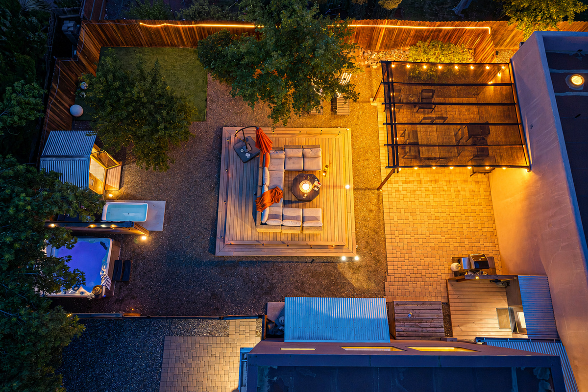 {Outdoor Spaces} An aerial view shows the private backyard, wellness area and multiple outdoor gathering spaces surrounding the home.