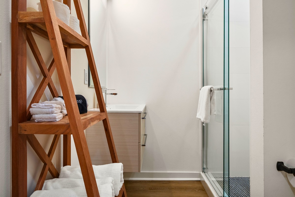 Bright bathroom featuring a walk-in shower and towel ladder for added style.