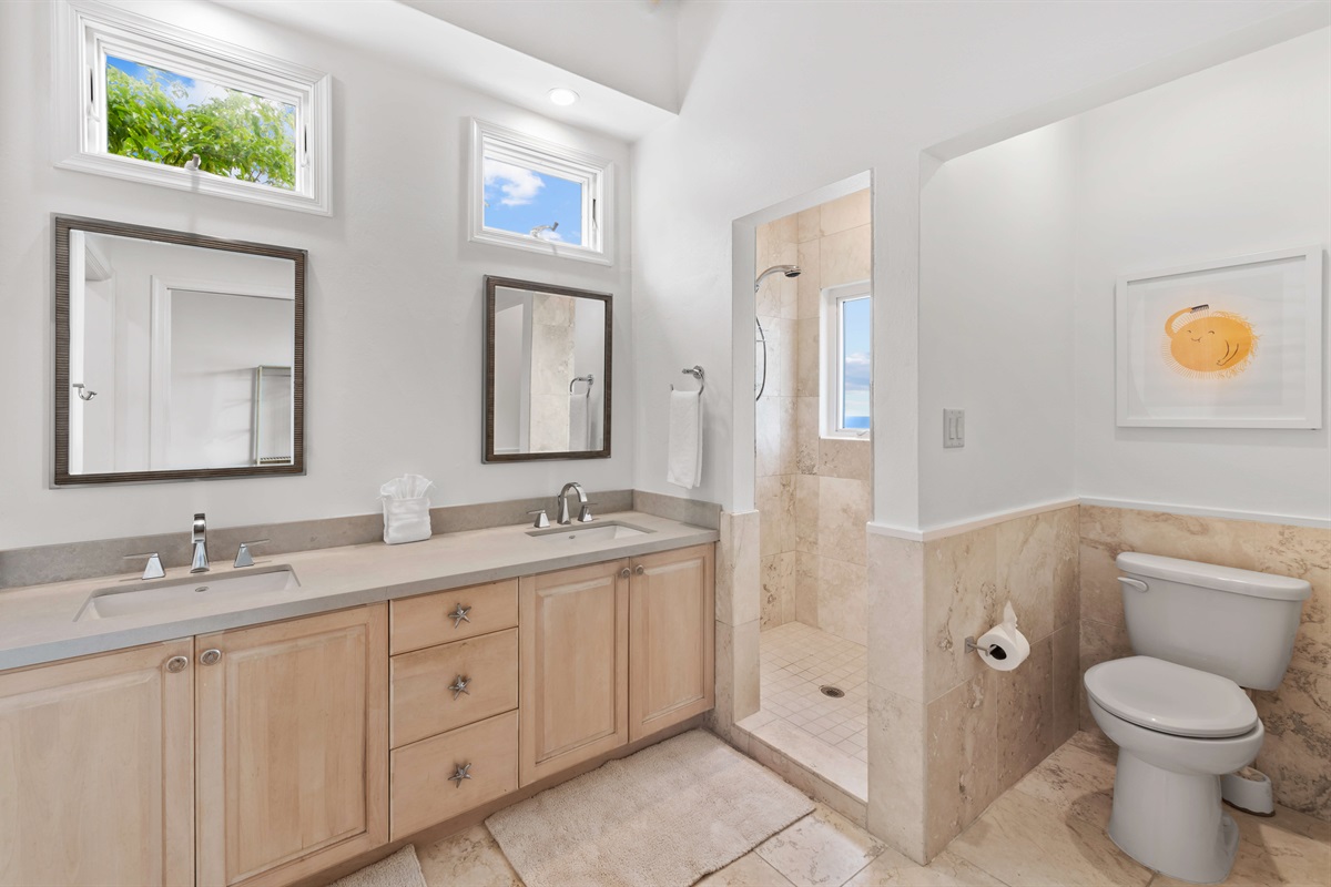 Sleek en-suite with double vanity, hair dryer, walk-in shower  and soft lighting. Functional and elegant.