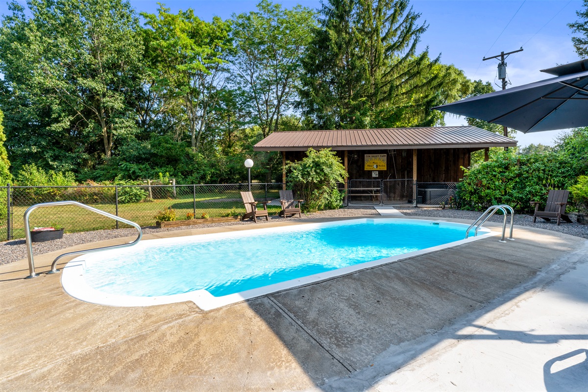 Relax and unwind by the sparkling private pool, surrounded by lush greenery and cozy seating for the perfect outdoor escape.