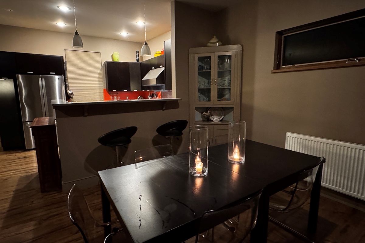 Warm evening ambiance in the main level dining area. This thoughtfully designed space bridges the gourmet kitchen and living area, offering a sophisticated setting for shared meals and storytelling after a day of Acadia adventures.