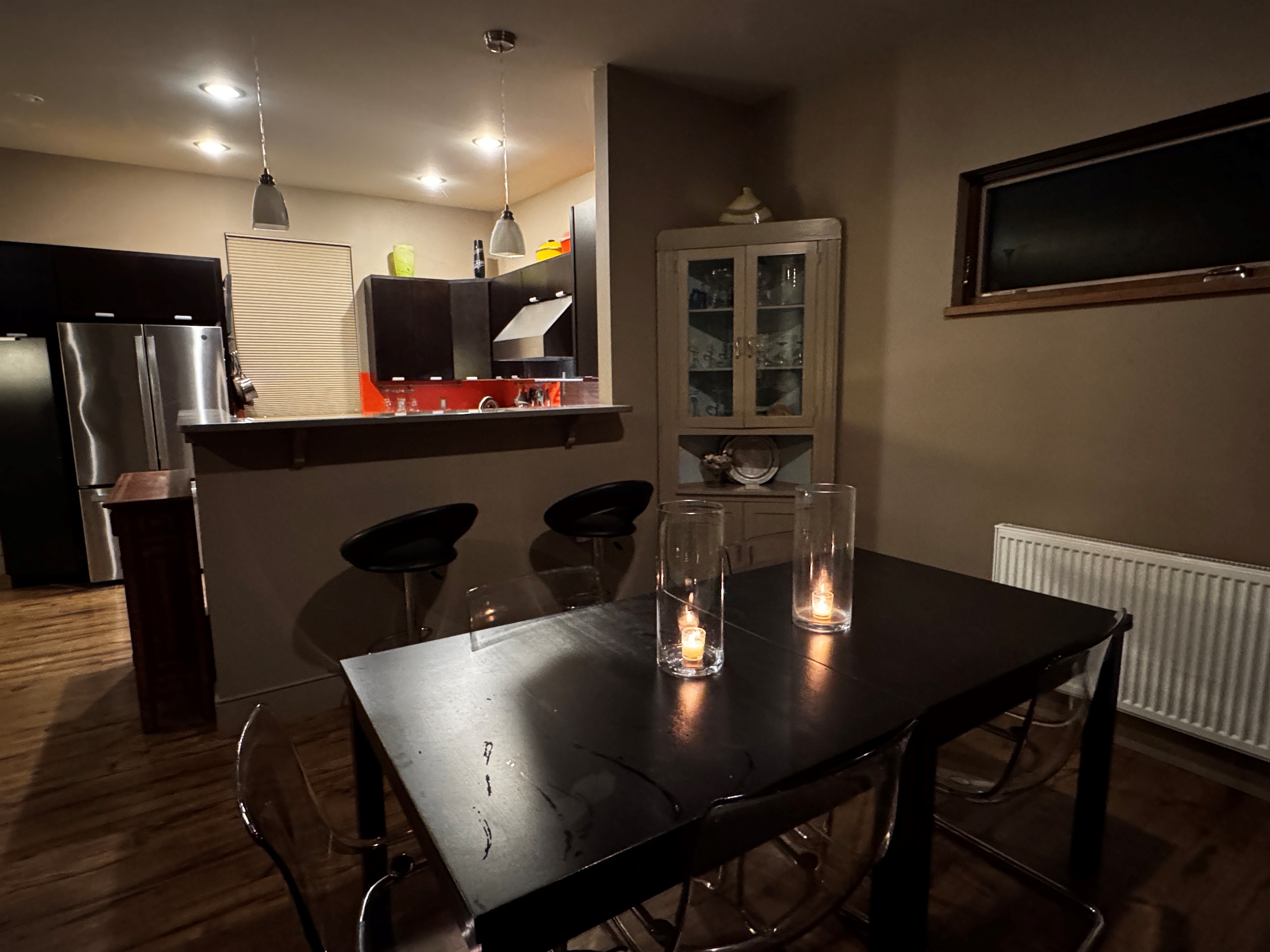 Warm evening ambiance in the main level dining area. This thoughtfully designed space bridges the gourmet kitchen and living area, offering a sophisticated setting for shared meals and storytelling after a day of Acadia adventures.