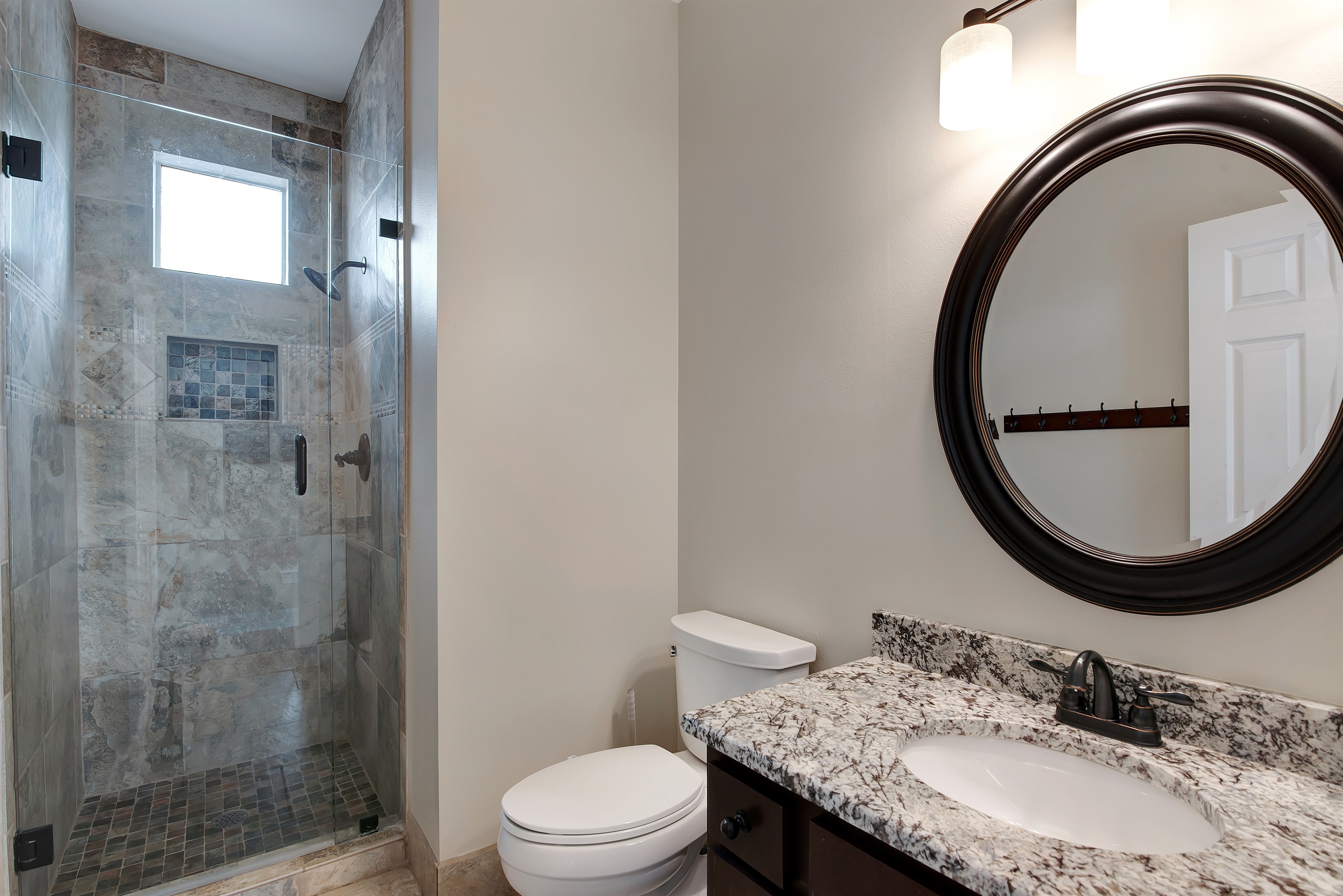 Bathroom with tiled walk‑in shower and granite vanity