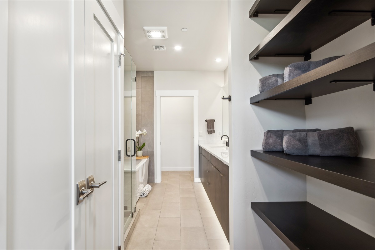 The master suite bathroom with double vanity, giant soaker tub, private toilet, and a tile shower.