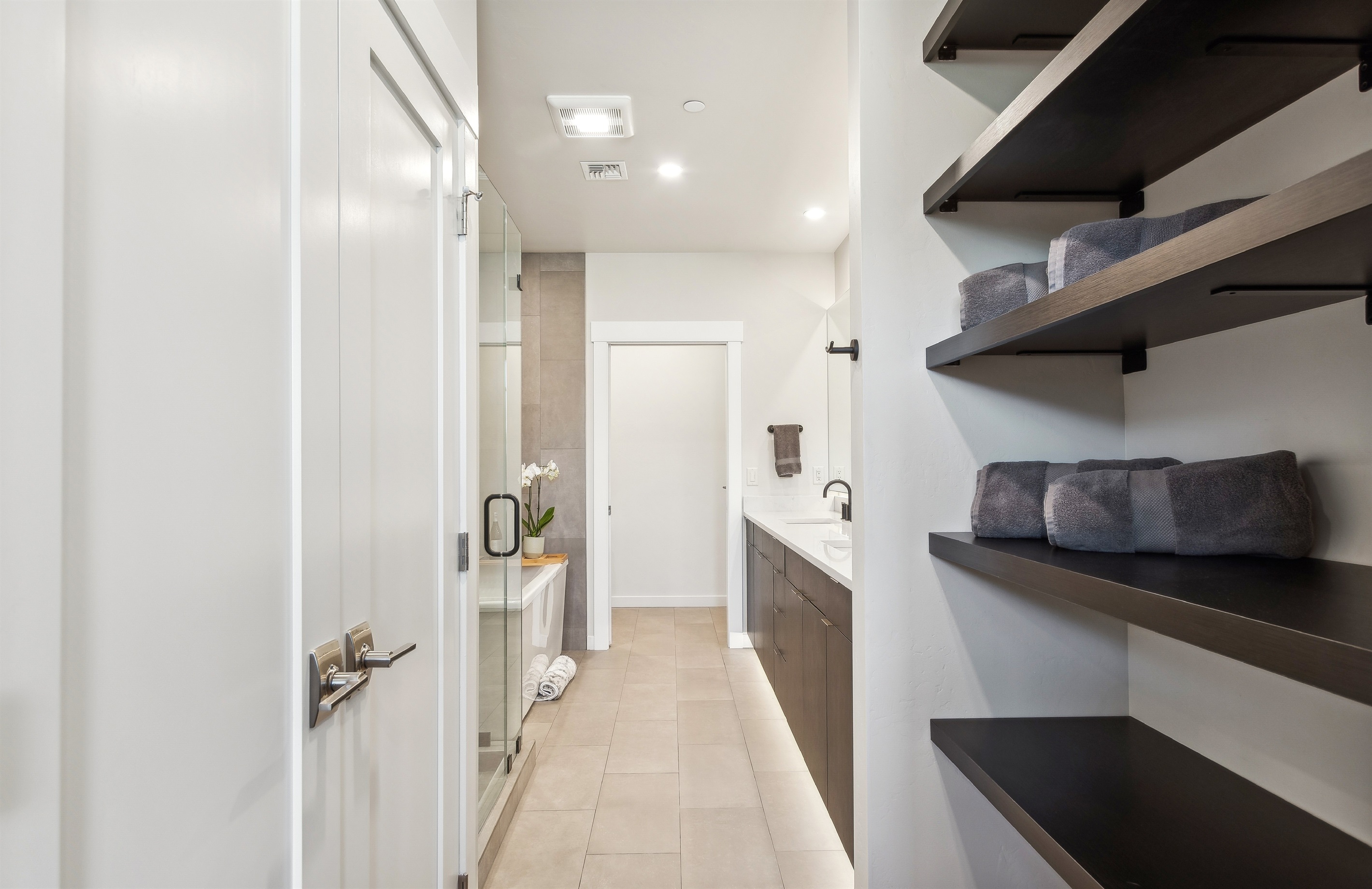 The master suite bathroom with double vanity, giant soaker tub, private toilet, and a tile shower.