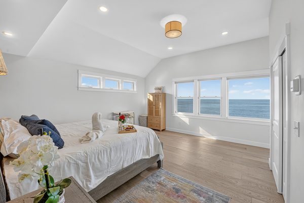 Spacious primary bedroom featuring stunning ocean views and abundant natural light