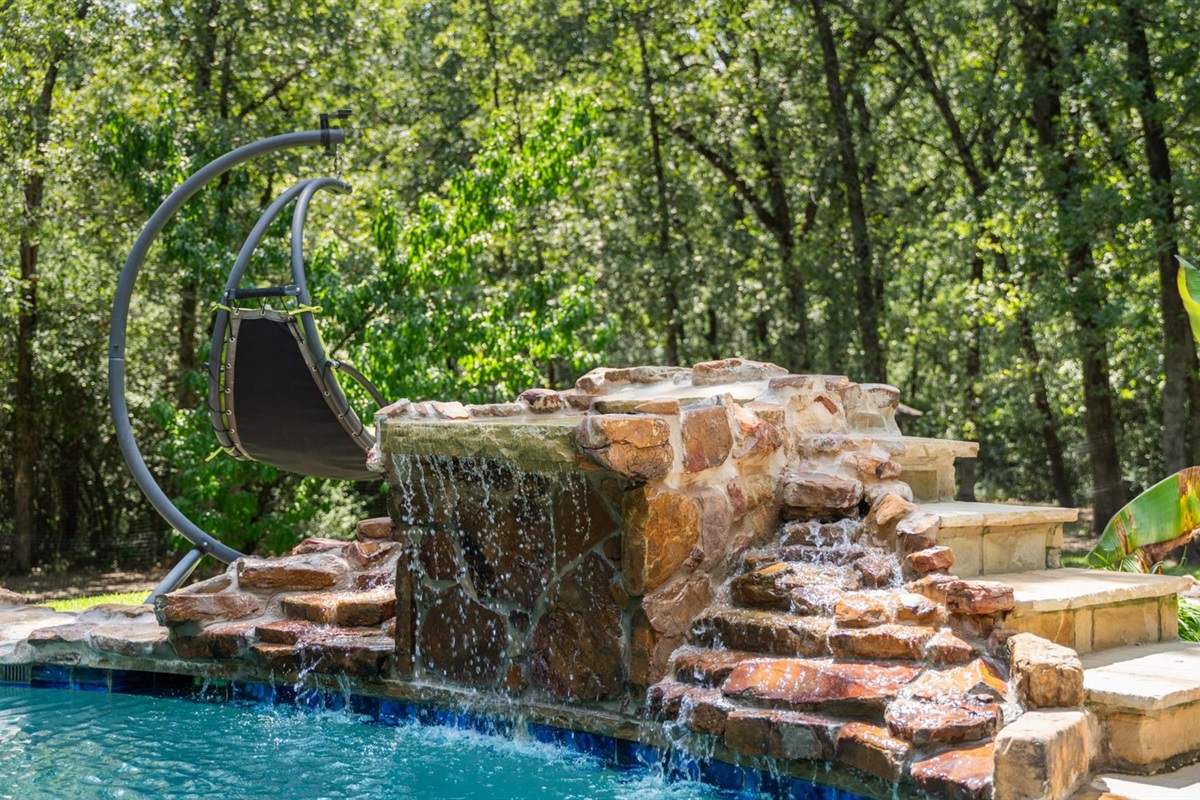 The pool features a built-in jumping rock—higher than a standard diving board—making it the perfect spot to show off your flips, tricks, or cannonballs.