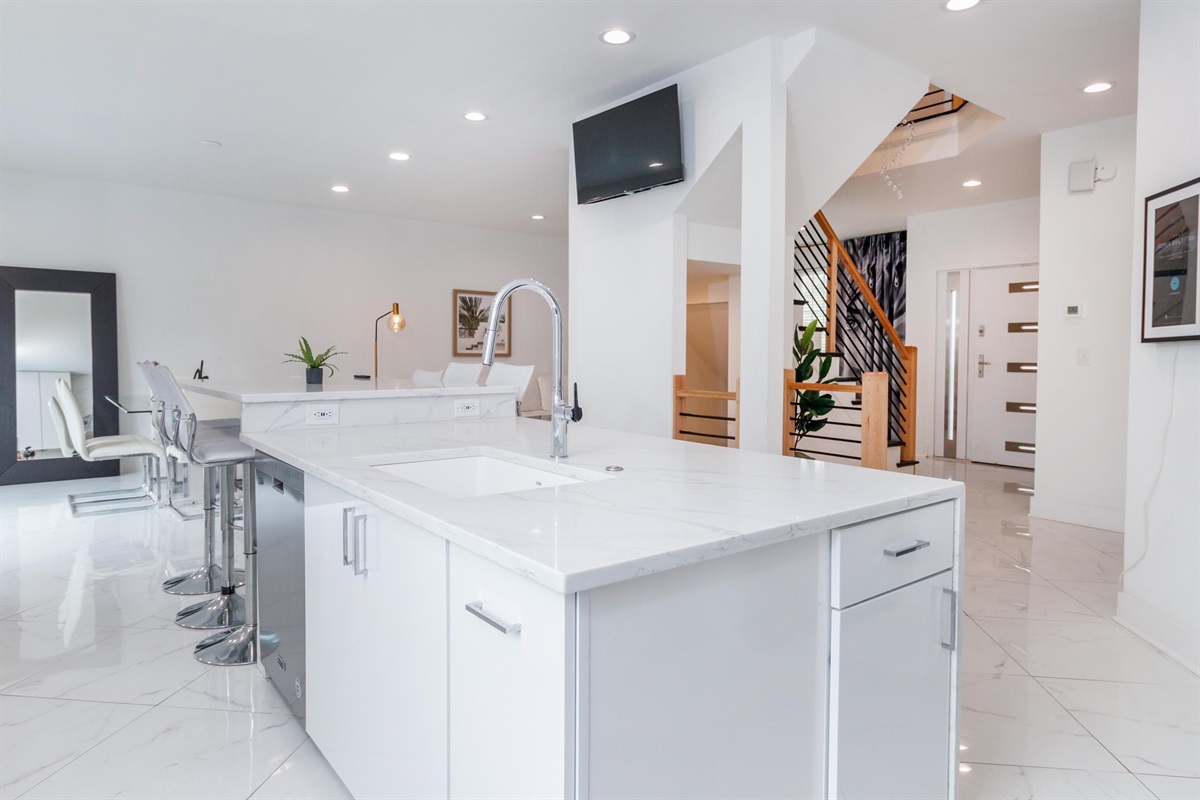 The open concept main floor has a 13 foot marble island with seating for 6 - and its own TV!